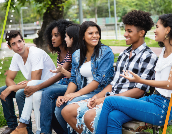 Group of teens sitting on a bench talking